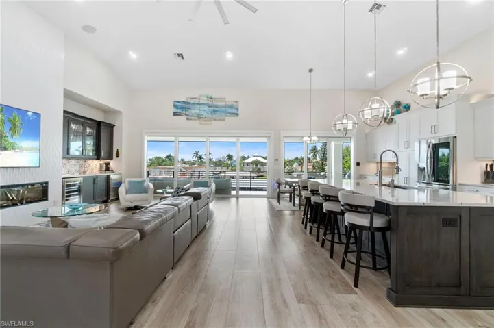 Great room with high vaulted ceiling, a healthy amount of sunlight, and feature wall.