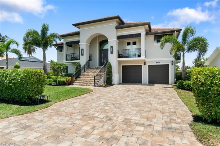 View of front of house with a garage and a balcony