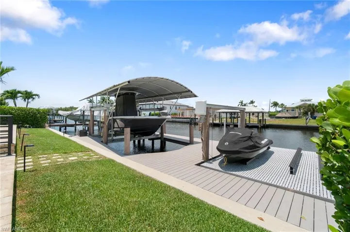 Boater's Dream Dock! Dock area featuring a 10,000 LB covered boat lift and 7,000 LB dual Jet Ski platform lift
