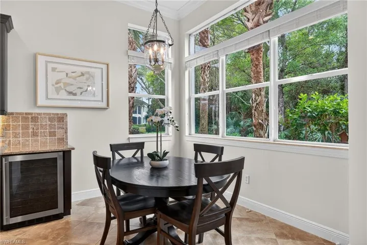 Dining room with beverage cooler, crown molding, and a chandelier