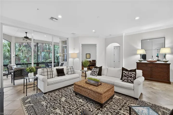 Living room with crown molding, recessed lighting, a ceiling fan, arched walkways, and light tile patterned flooring