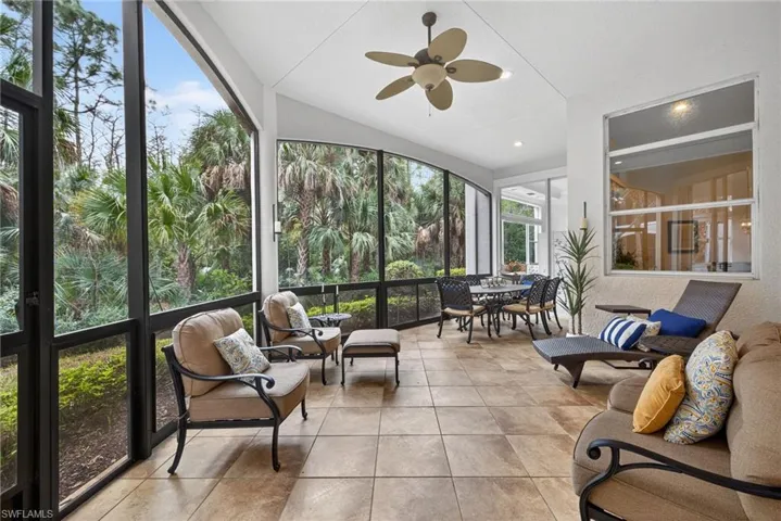 Sunroom / solarium featuring lofted ceiling and a textured wall