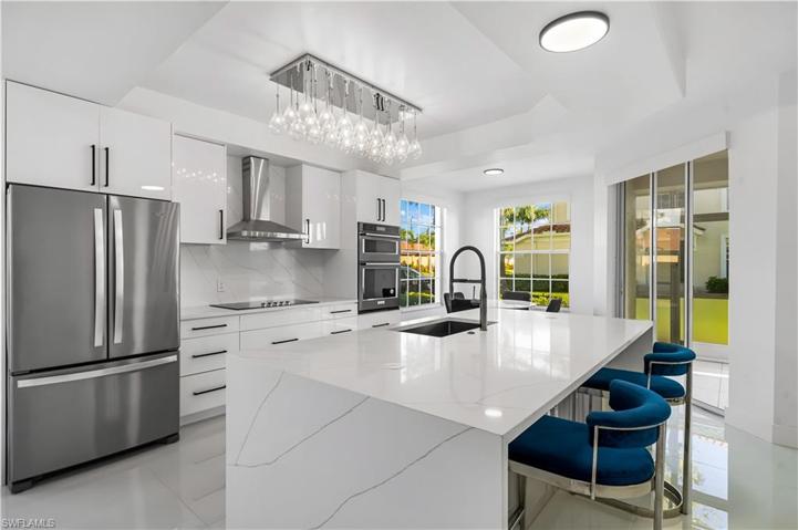 Light and bright condo has fabulous views of the lake and open space! Quartz waterfall island with storage.   French drawer refrigerator, backsplash, farm sink!