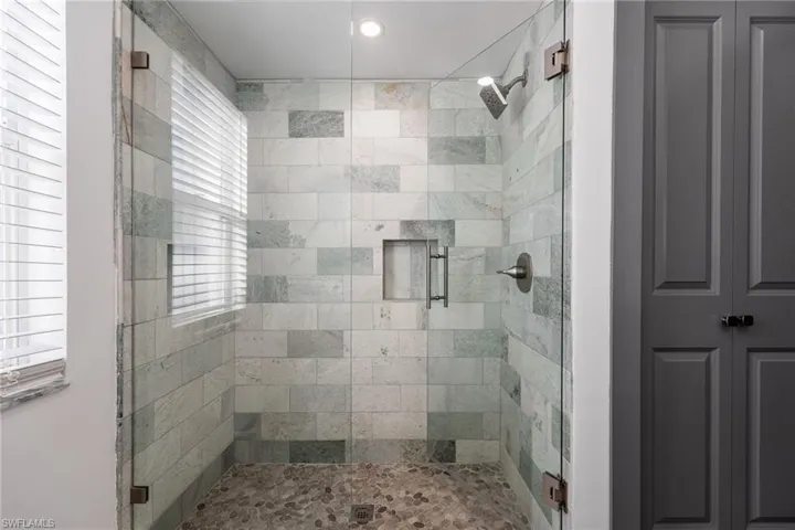 Bathroom with a stall shower and recessed lighting