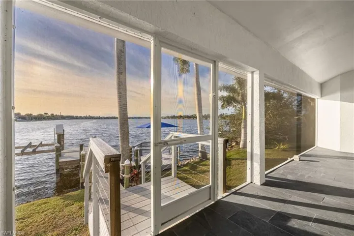 Bright lanai featuring a water view and lofted ceiling