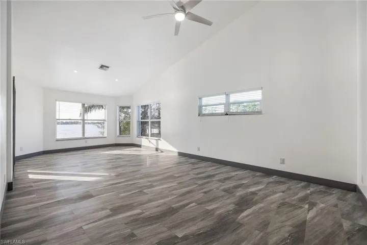 Master bedroom with high vaulted ceiling and a ceiling fan