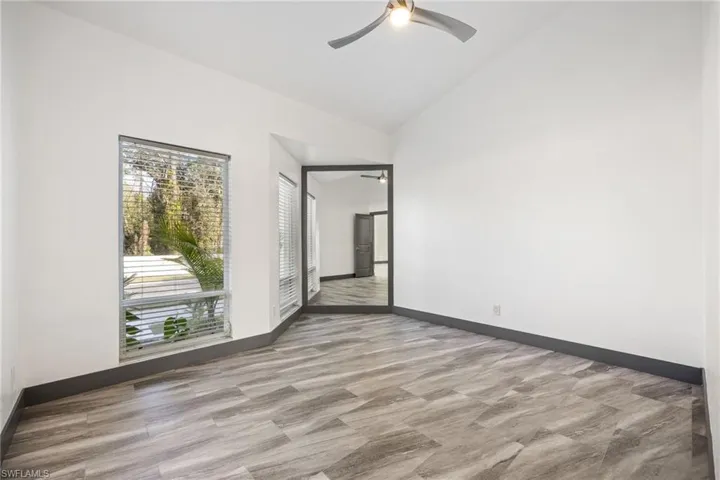 Empty room featuring lofted ceiling and ceiling fan