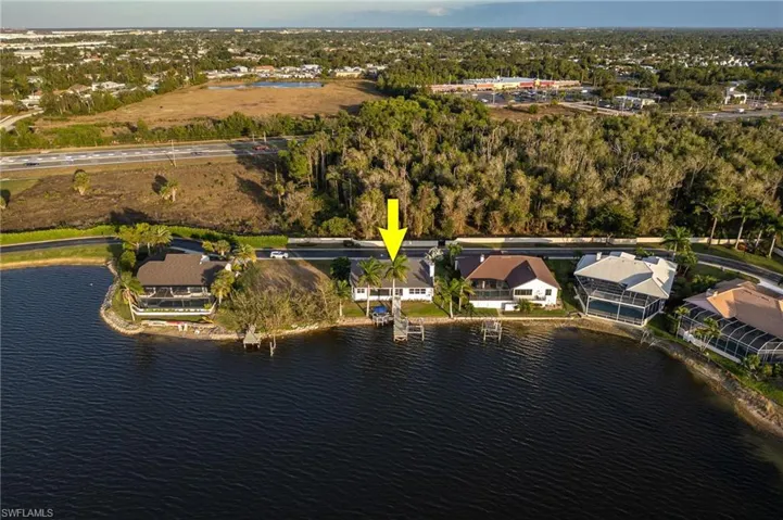 Aerial view of property's location with a large body of water and nearby suburban area