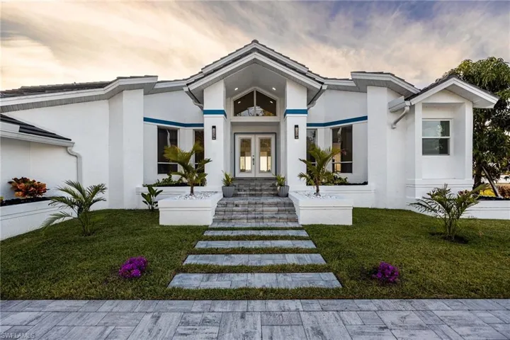 Property entrance featuring french doors, stucco siding, and a yard