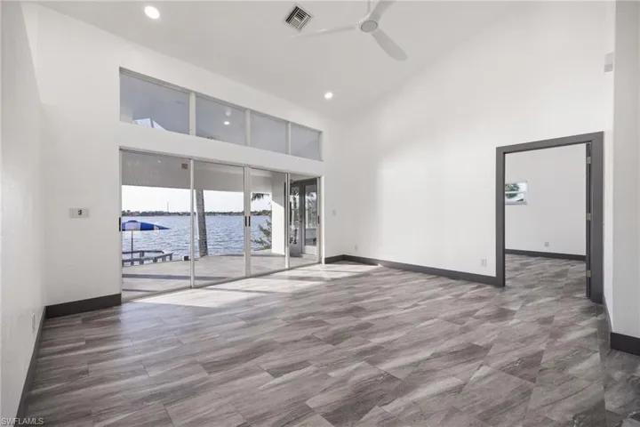 Dining room featuring high vaulted ceiling, ceiling fan, a water view, and recessed lighting