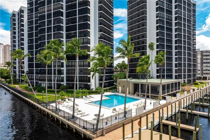 View of swimming pool with a water view and a patio area