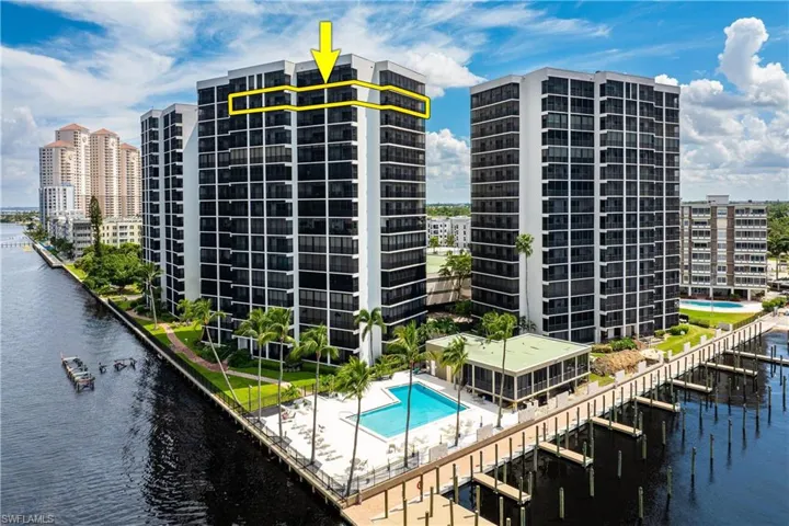 View of building exterior with a community pool and a water view