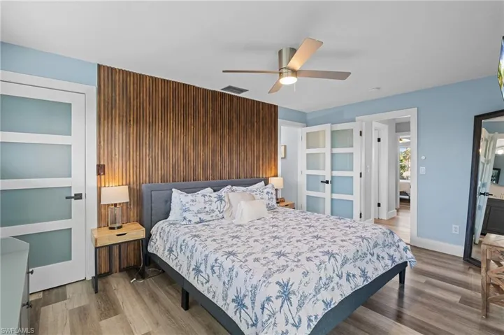 Bedroom featuring wood finished floors, visible vents, a ceiling fan, and baseboards