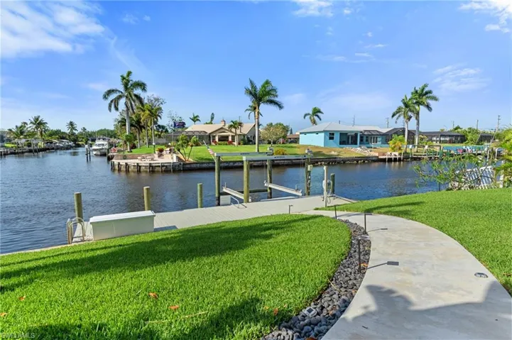 Dock area with a residential view, a lawn, and a water view  - Virtually Edited Image