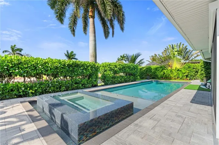 View of pool with a patio, a fenced in pool, and an in ground hot tub  - Virtually Edited Image