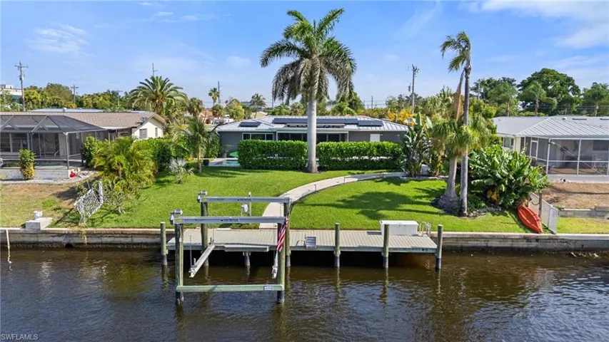 View of dock with a lawn and a water view  - Virtually Edited Image