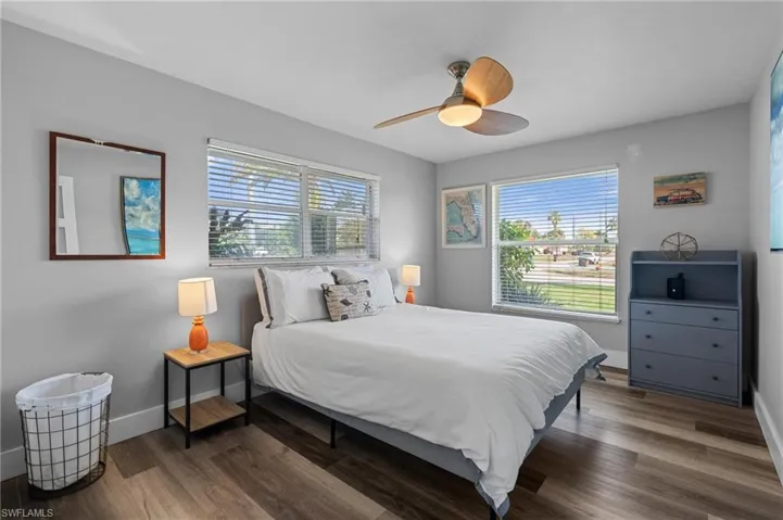 Bedroom featuring baseboards, a ceiling fan, and wood finished floors  - Virtually Edited Image