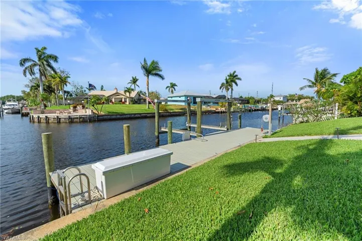 View of dock featuring a yard and a water view  - Virtually Edited Image