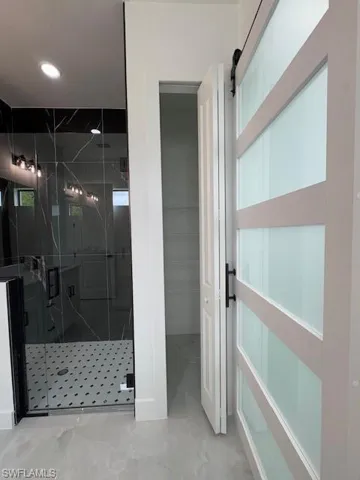 Full bathroom featuring a stall shower, a spacious closet, linen closet and marble finish flooring
