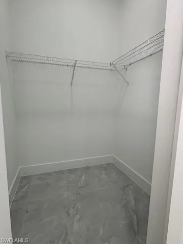Walk in closet featuring marble finish floors