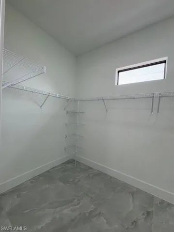 Spacious master's closet featuring marble finish flooring