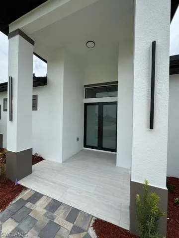 Entrance to property with french doors and stucco siding