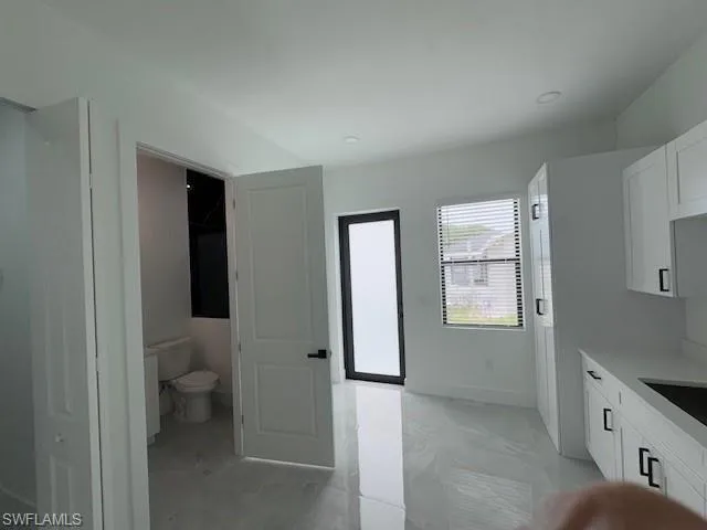 Full bath with vanity and marble finish floors