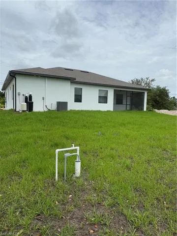 Back of property featuring stucco siding and a yard