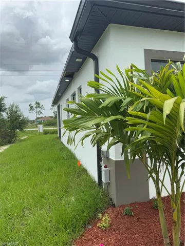 View of left side of property with stucco siding and a yard