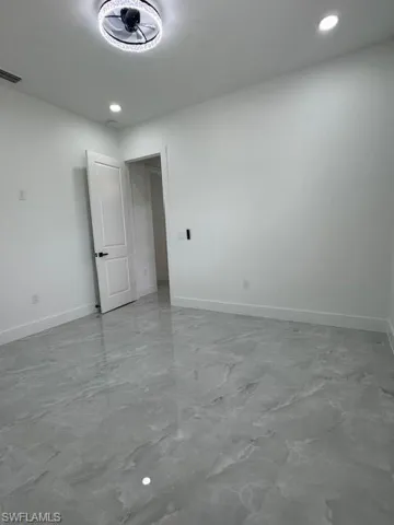 Unfurnished room featuring marble finish floors and recessed lighting
