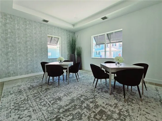 Dining space featuring baseboards and a tray ceiling