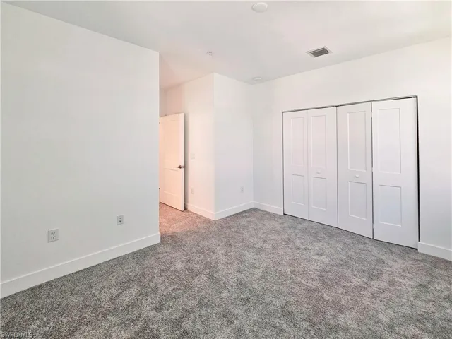 Unfurnished bedroom with carpet flooring, baseboards, and a closet