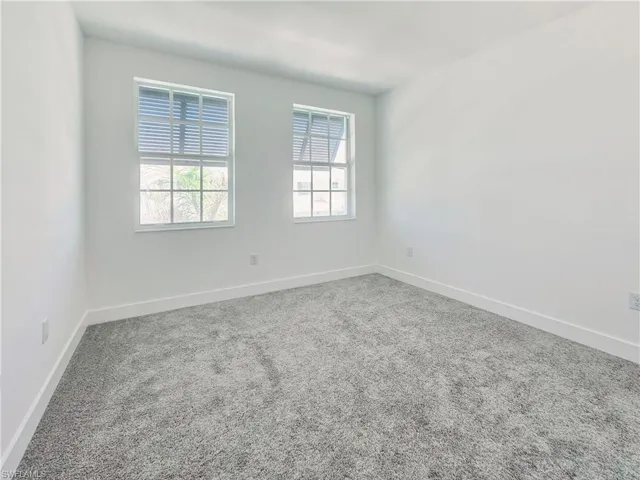 Spare room featuring baseboards and carpet floors