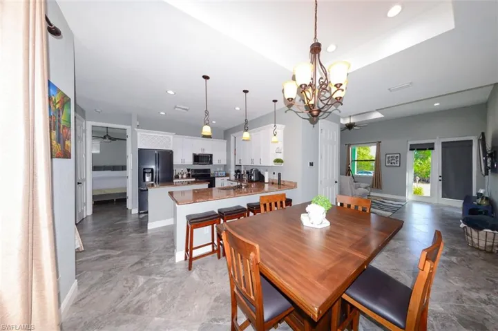 Dining room with a ceiling fan, recessed lighting, and a chandelier