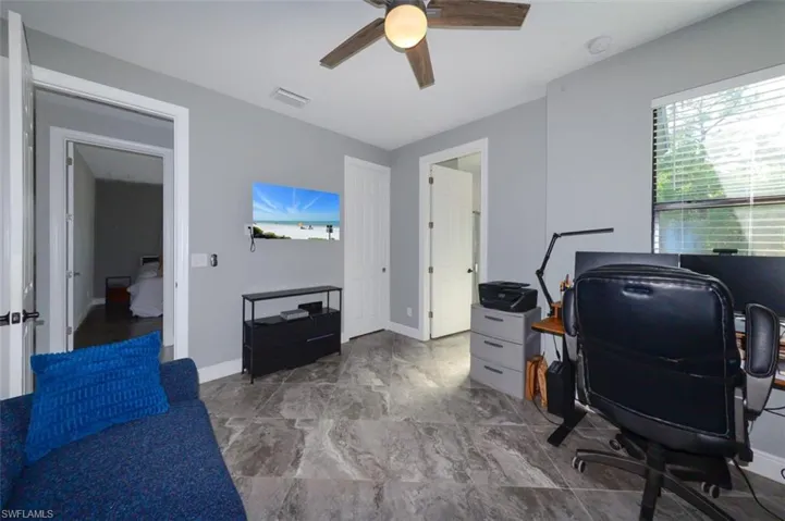 Office area with a ceiling fan and baseboards