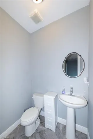 Bathroom featuring baseboards and toilet
