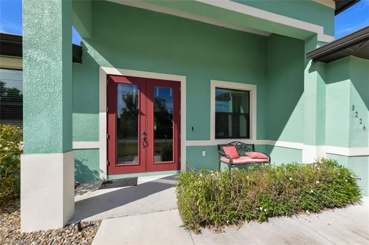 Doorway to property with french doors, stucco siding, and a porch