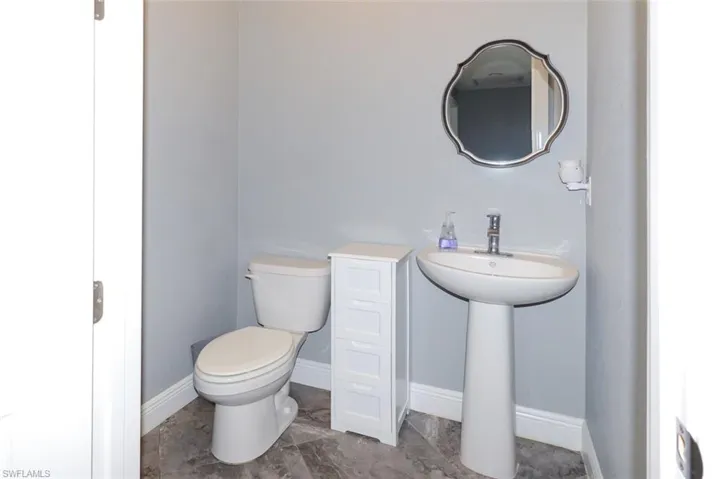 Half bathroom featuring toilet and baseboards