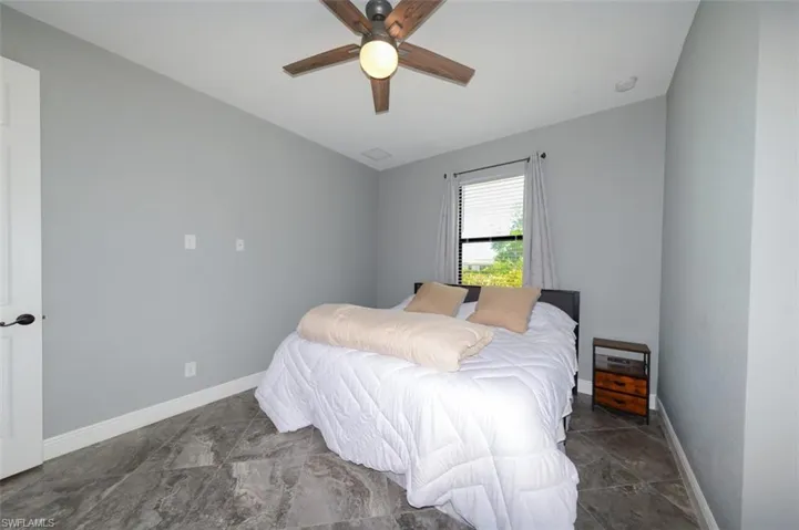 Bedroom featuring ceiling fan and baseboards