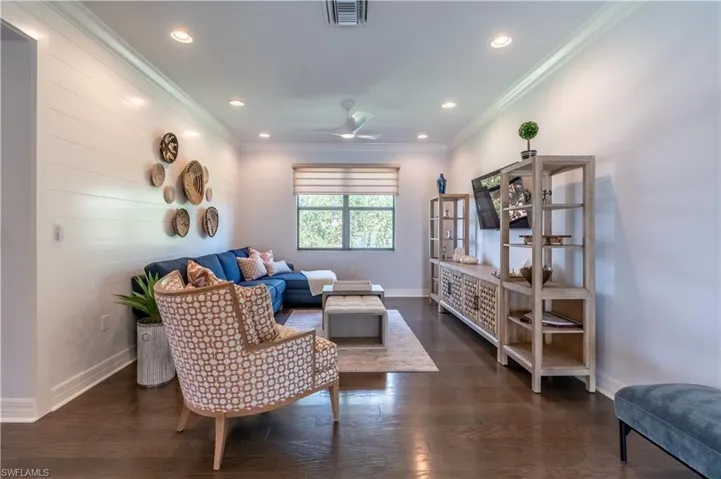 Bright living area featuring dark wood-finish flooring, recessed lighting, and crown molding