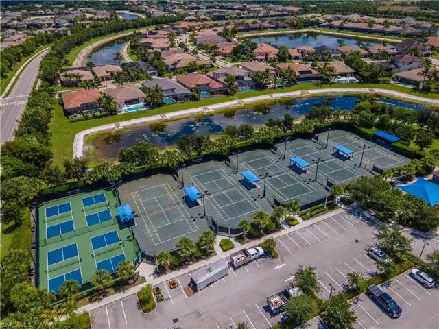 Community recreational area featuring multiple tennis courts, pickleball courts, and mature landscaping
