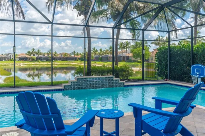 Screened lanai featuring a swimming pool with a decorative tiled waterfall