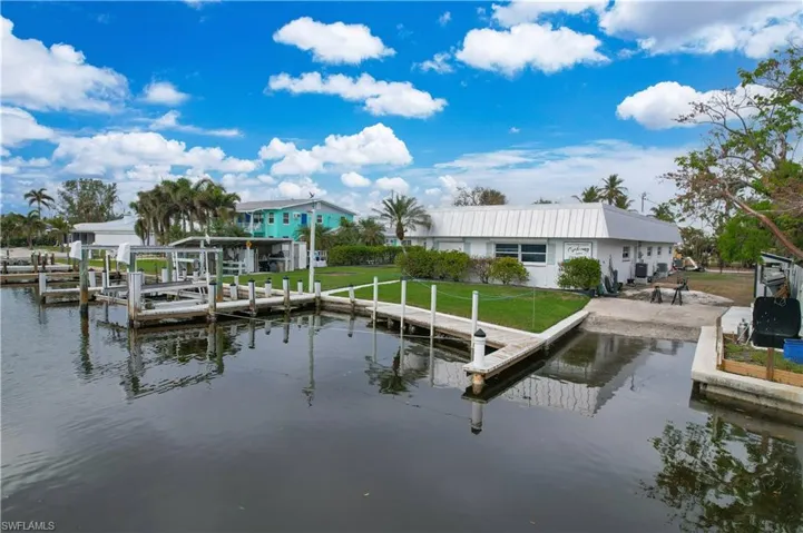 Dock area with a lawn and a water view