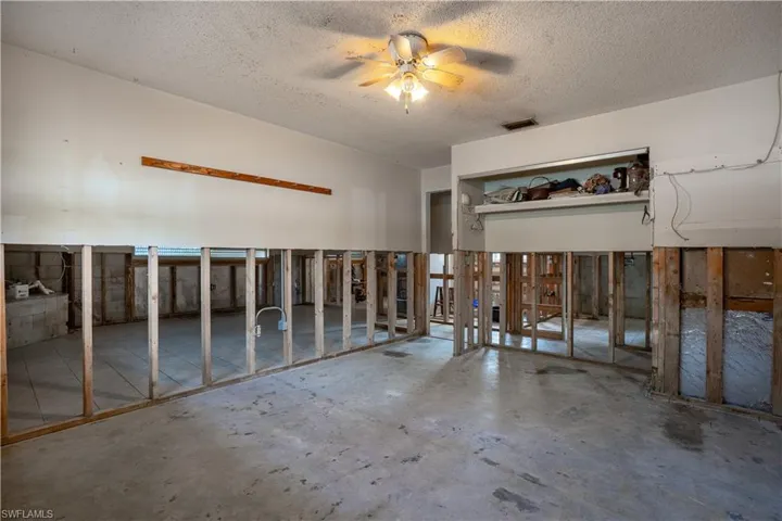 Misc room featuring a textured ceiling, concrete floors, and ceiling fan