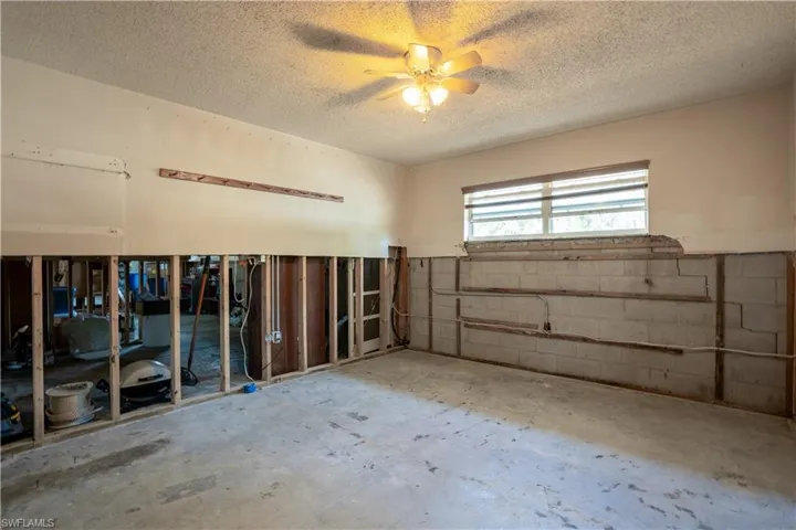 Basement featuring a textured ceiling and ceiling fan