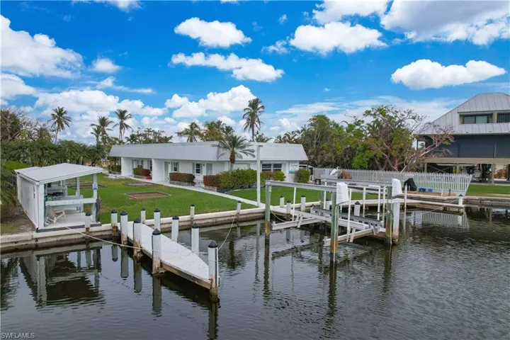 View of dock featuring a water view and a lawn