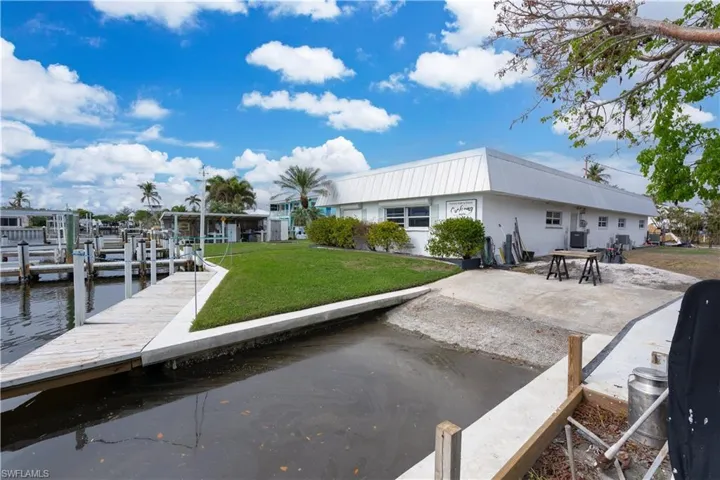 View of dock with a yard and a water view