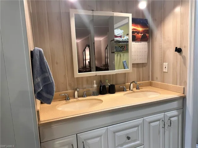 Bathroom featuring wooden walls and vanity