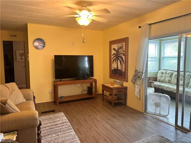 Living room with ceiling fan and hardwood / wood-style floors