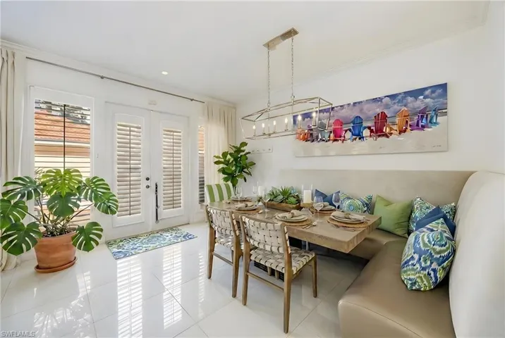 Tiled dining space featuring french doors, ornamental molding, a chandelier, and breakfast area